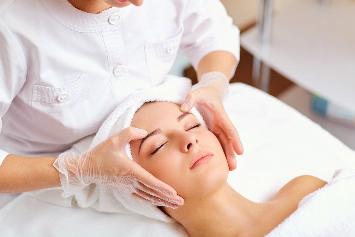 Woman getting chemical peel treatment, massaging face