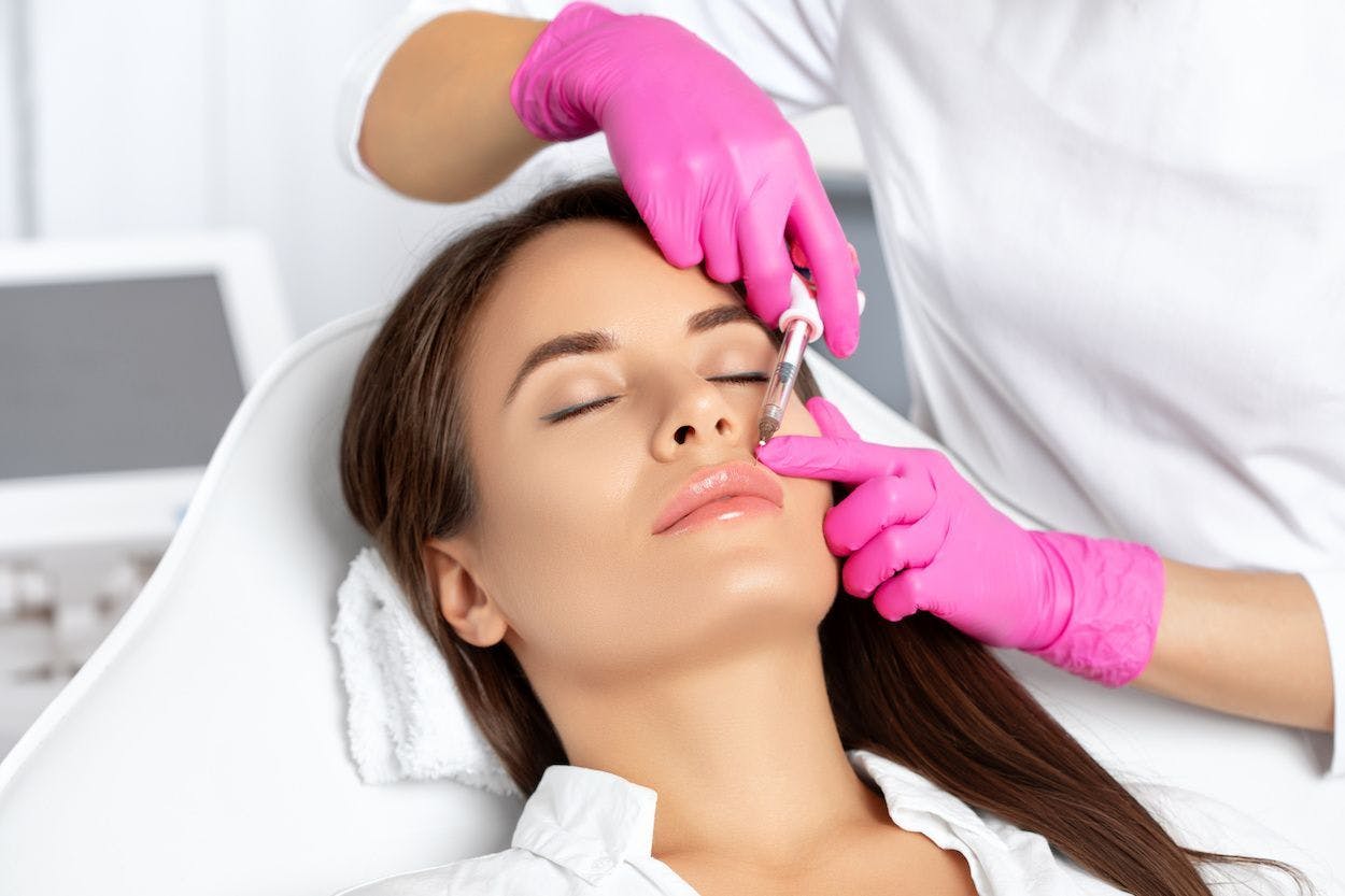 Woman getting platelet rich plasma facial, injecting above lip