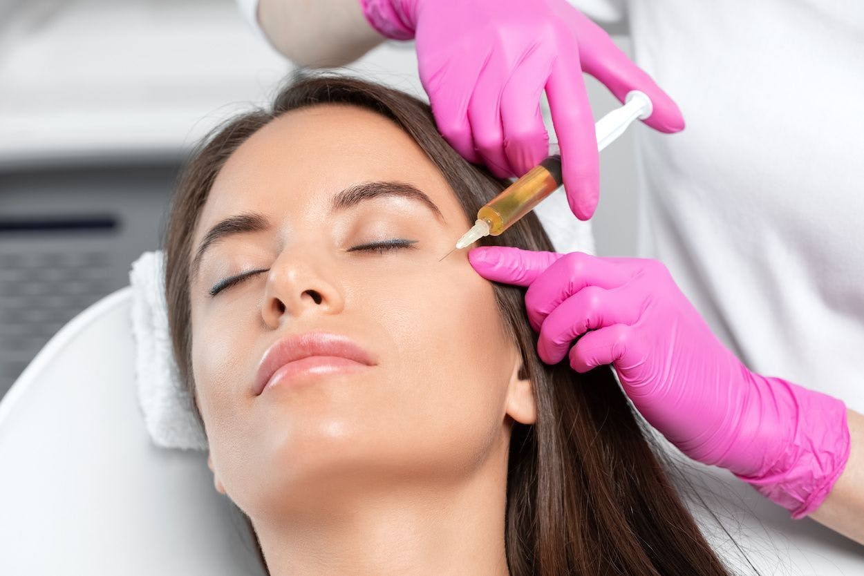 Woman getting platelet rich plasma facial, injecting beside eye